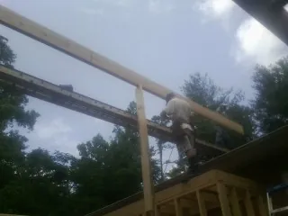 Carpenter setting a ridge beam over a new addition frame — Ice Dam Removal by Roofing Brothers in New Bloomfield