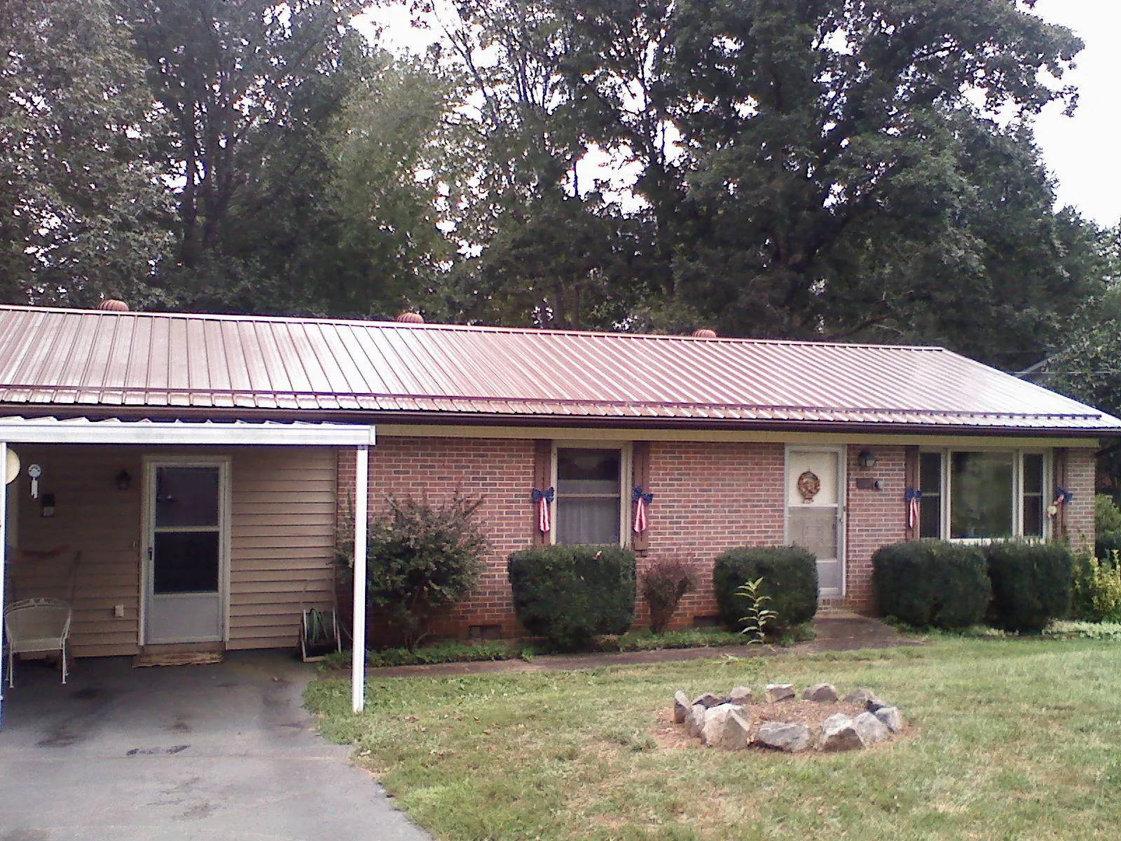 Bronze metal roof and carport on a brick ranch home — Roof Repair work by our crew in New Bloomfield