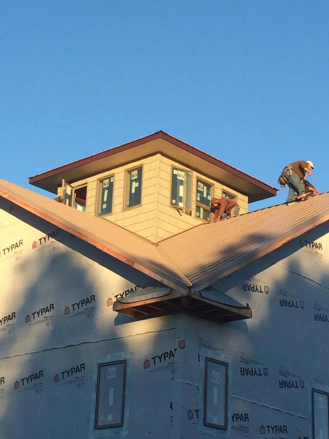 Roofers working around a rooftop cupola on a new metal roof at sunset — Roof Waterproofing in New Bloomfield by Roofing Brothers